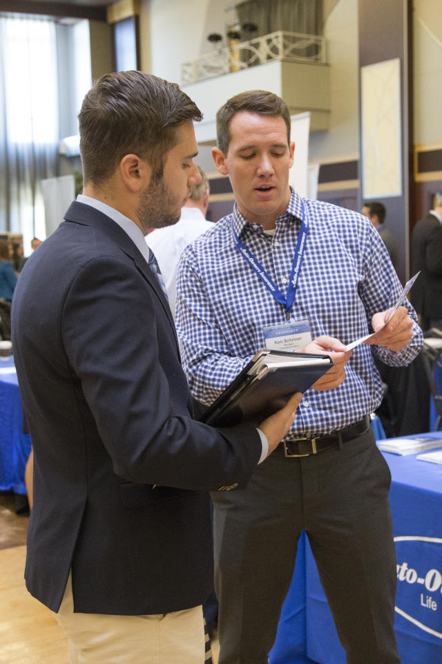 An employer showing information about his company to a student at a career fair.