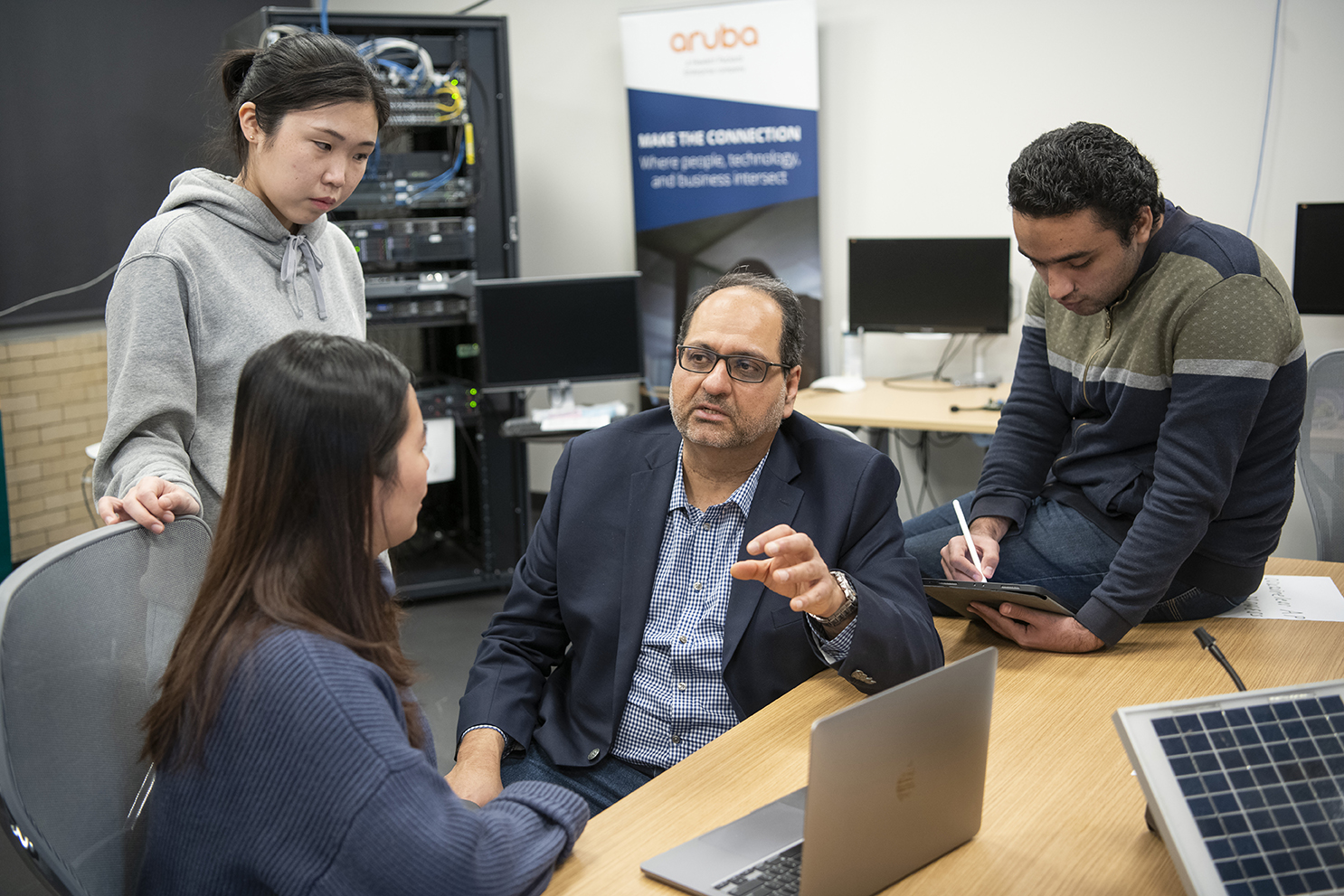 Academic and students sitting at a computer