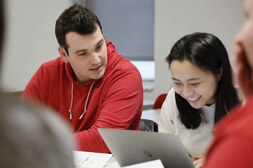 Two people looking over a laptop
