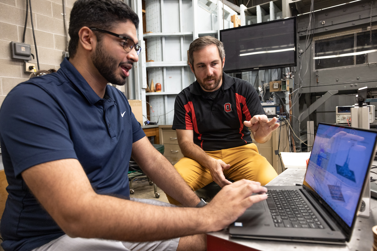 Two students examine something closely.