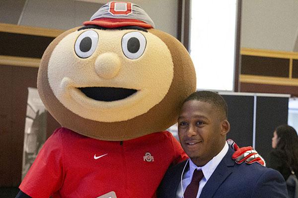 Brutus and student stand shoulder to shoulder